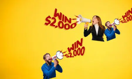 Three people cheer with megaphones as bold red 'Win $2,000' text circles across a bright yellow background.
