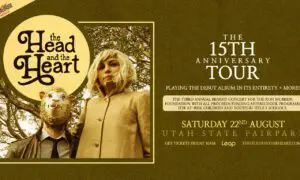 Poster for The Head and the Heart 15th Anniversary Tour with a masked man and blonde woman beside the logo against an olive background.